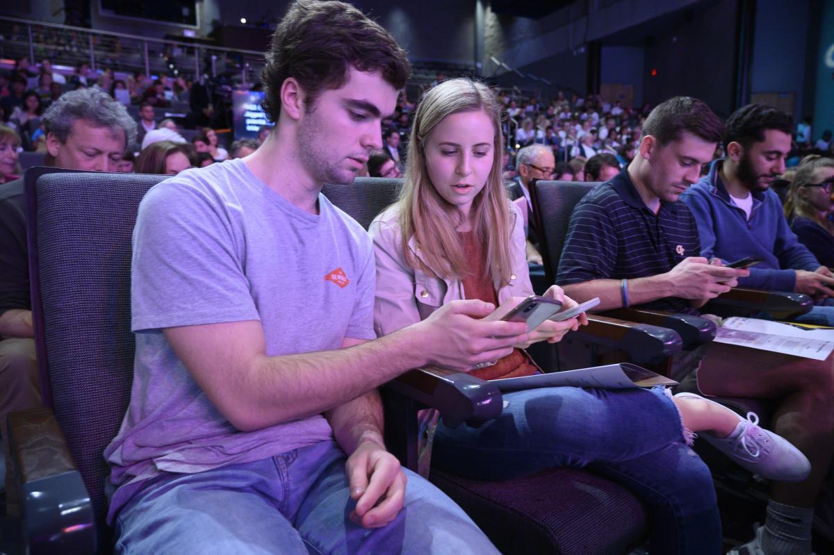 Audience members on their phone